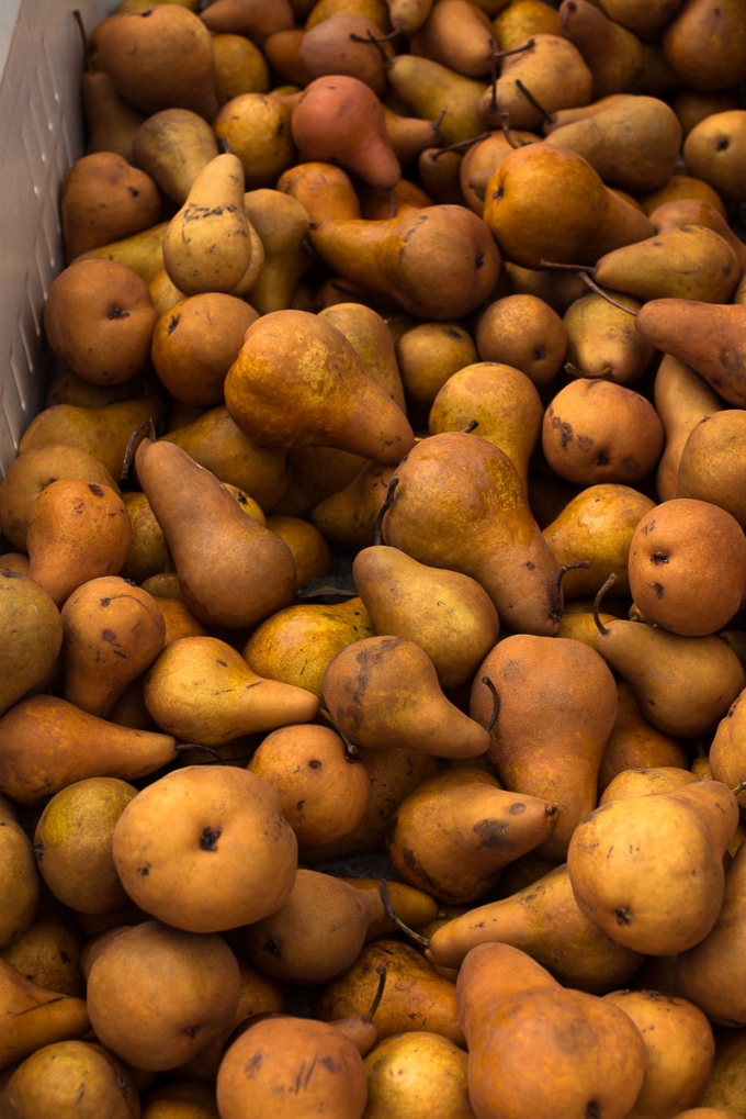 Golden pears, piled in a large produce box at the farmers market.