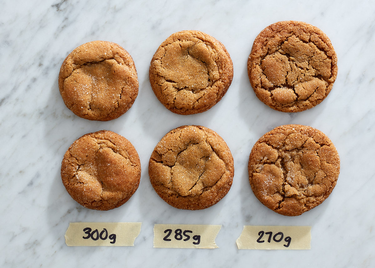 The very best chewy molasses cookies via forkknifeswoon.com | Three different molasses cookie recipes, using different amounts of flour, on a marble counter.