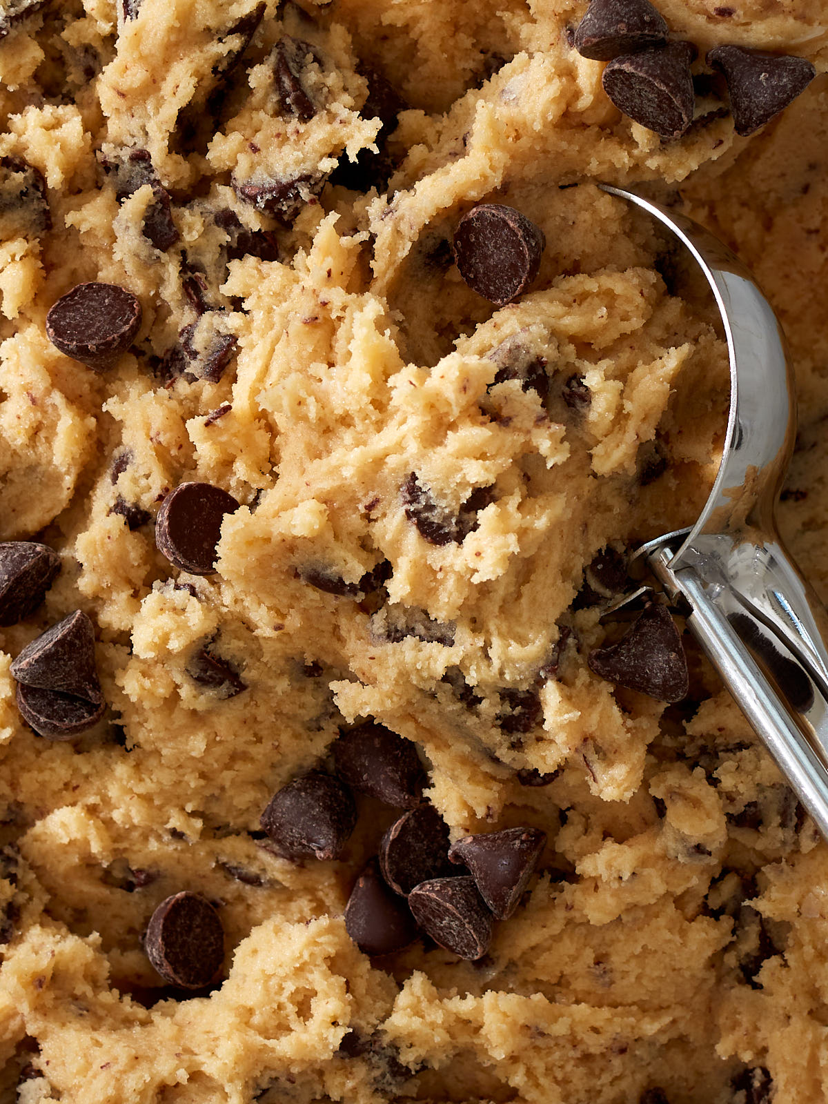 A closeup of chocolate chip cookie dough, ready to be scooped.
