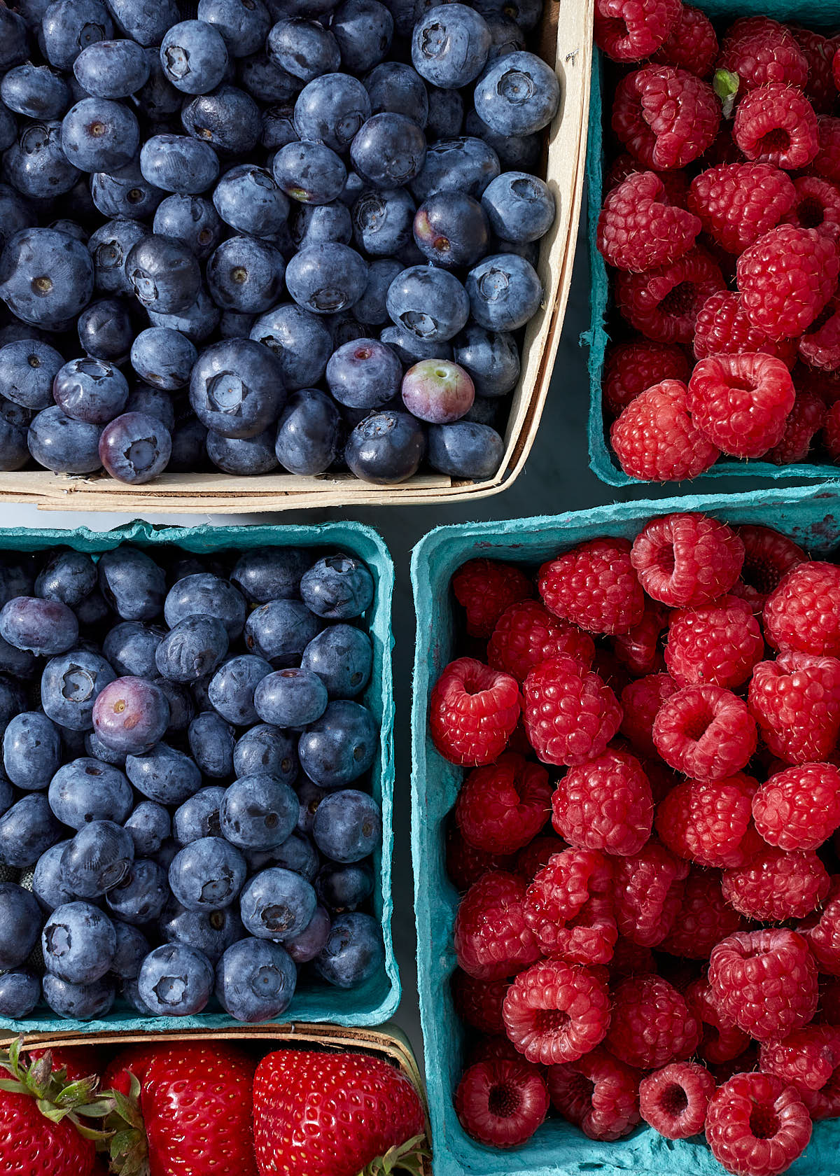 A close up of fresh blueberries, raspberries, and strawberries from the farmers market.