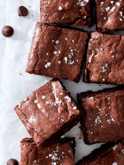 Chewy brownies with flake sea salton white parchment paper.