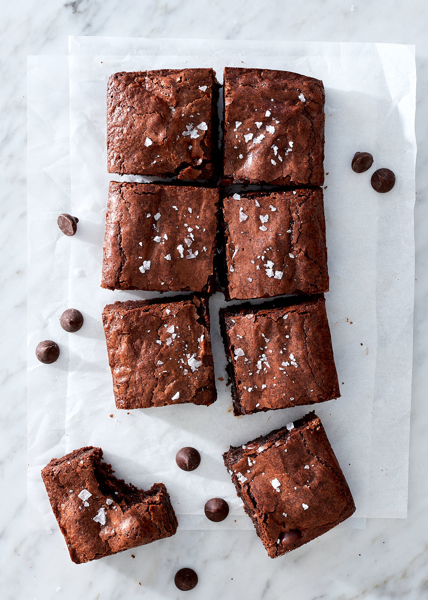 Chewy brownies with flake sea salton white parchment paper.