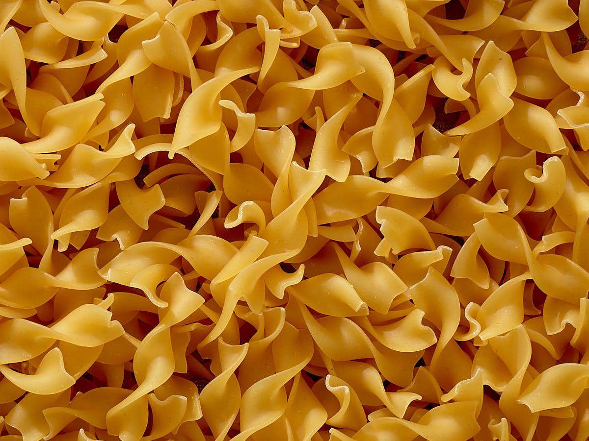 Close up of curly wide egg noodles.