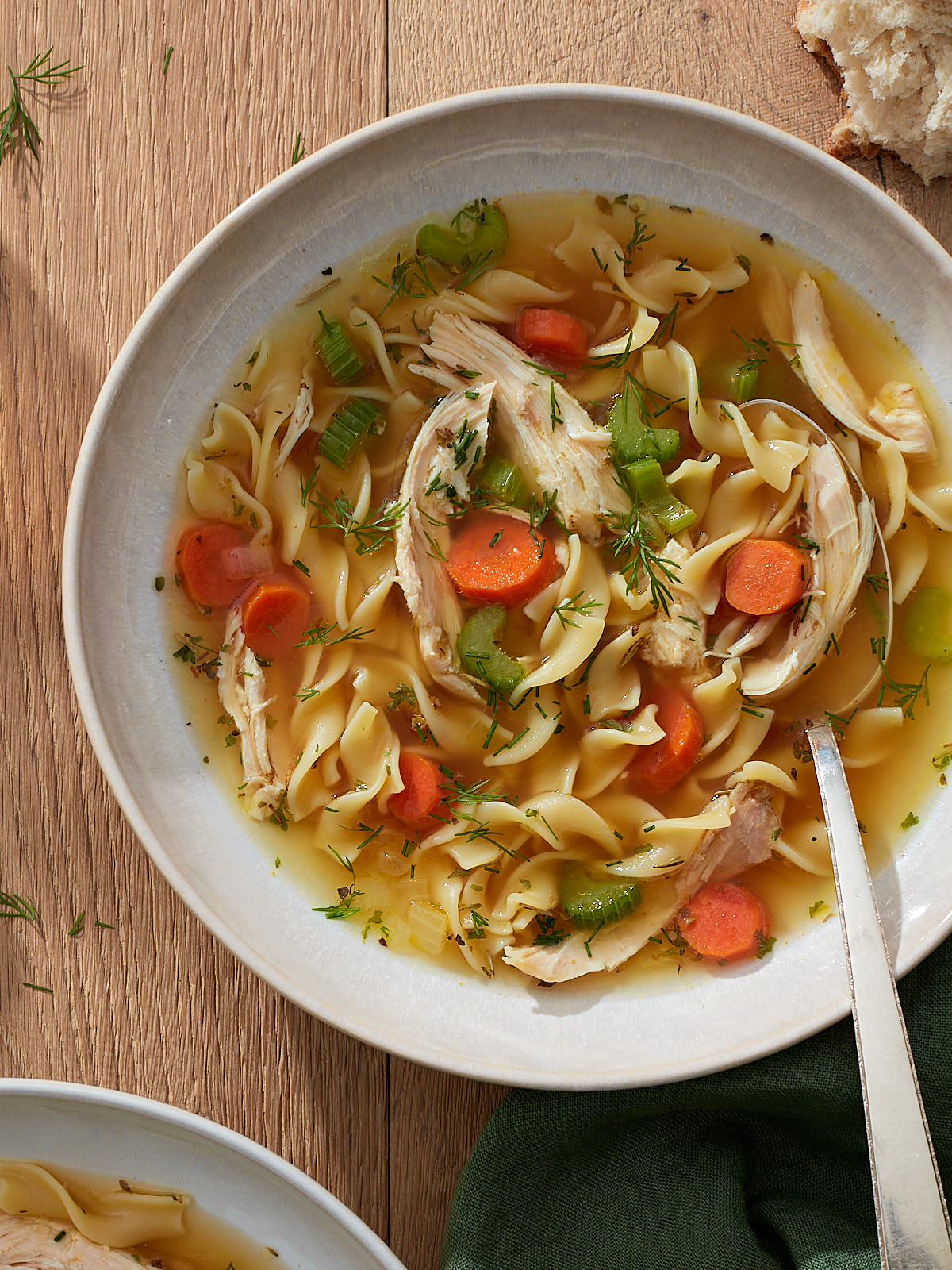 Homemade chicken noodle soup in a large bowl on a wooden table.
