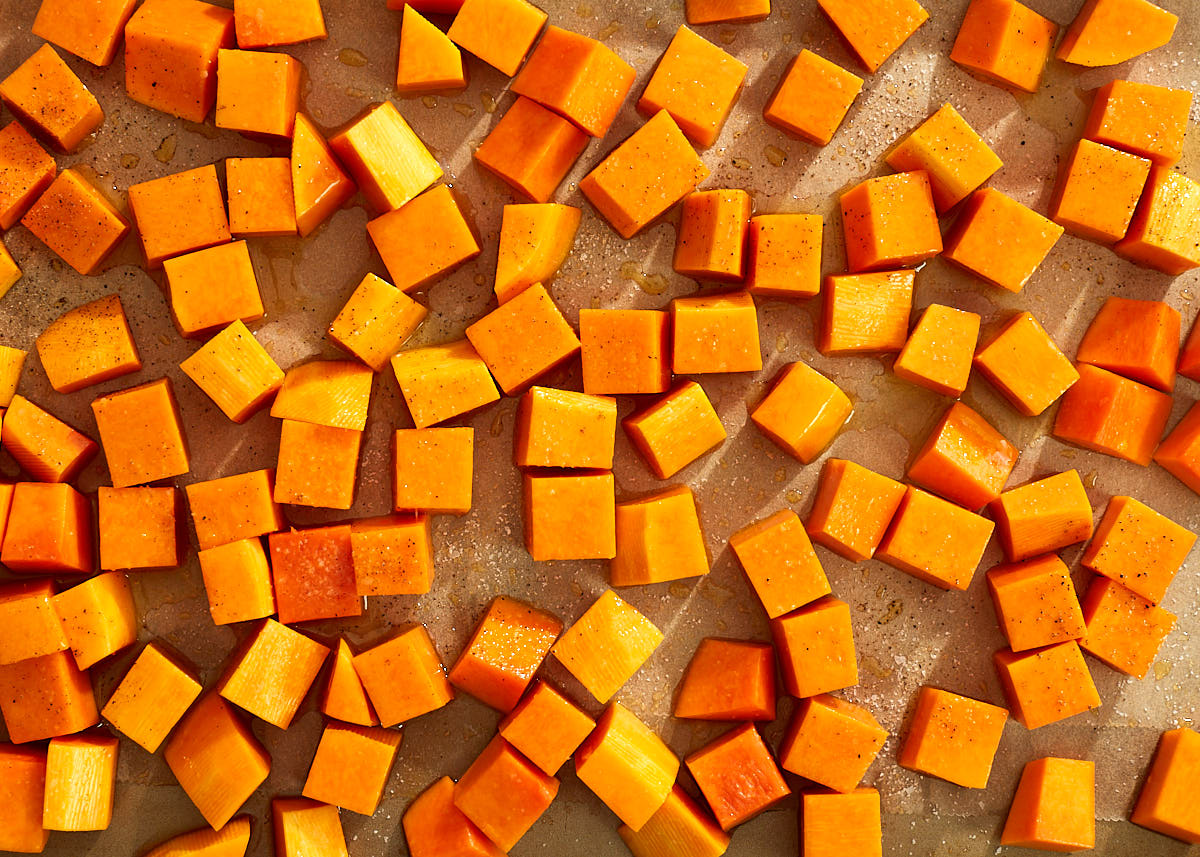 Pumpkin chunks on a sheet pan, ready to be roasted.